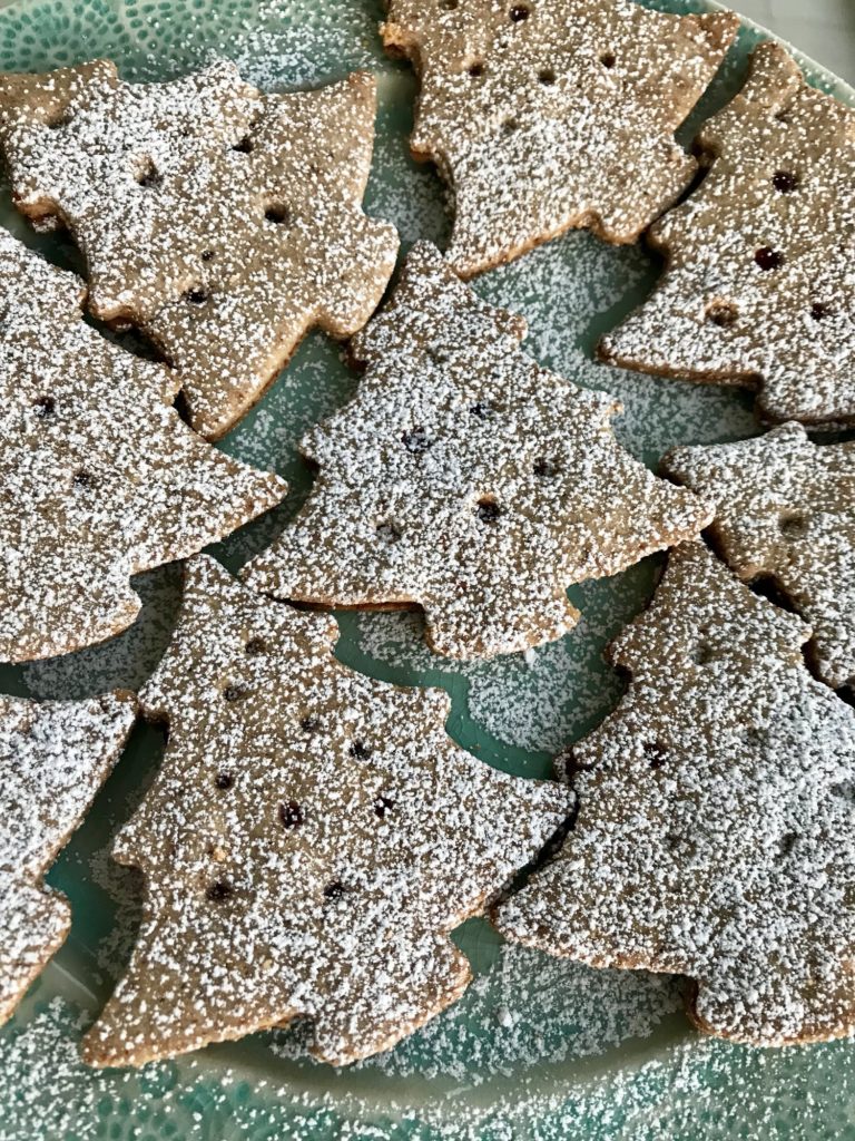 Čokoládové vianočné pečivo v tvare stromčeka, zdobené posypkou z cukru a škorice.