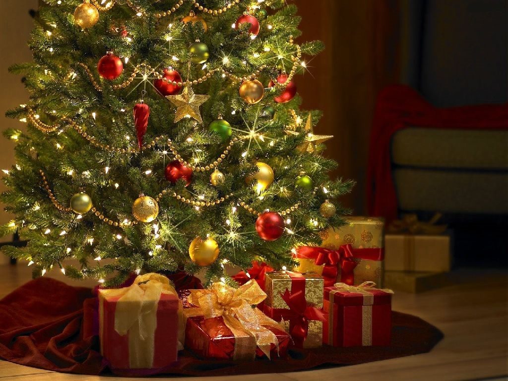 Prianie s vianočným obrázkom ozdobeného stromčeka a červenými darčekmi, oviazanými zlatými stuhami.