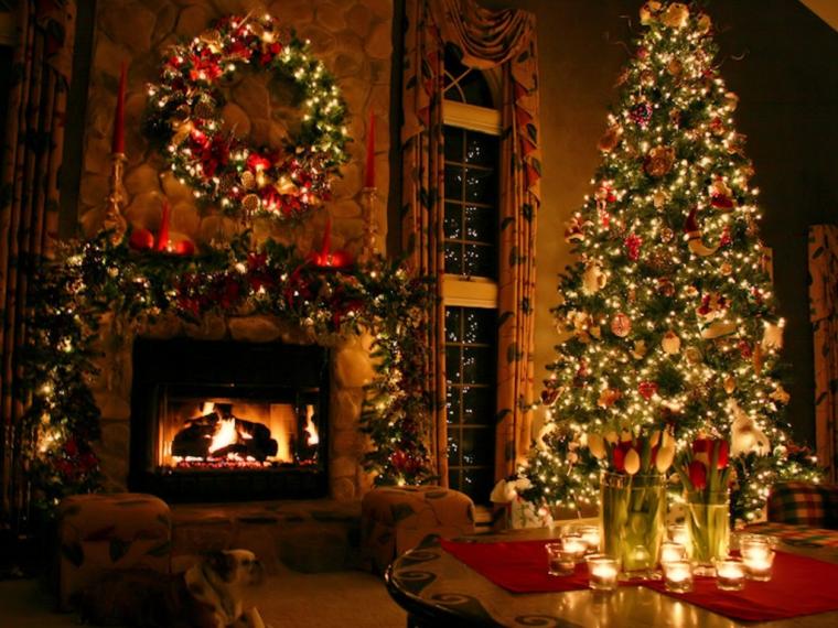 Izba na vianočnom obrázkovom prianí so svietiacimi dekoráciami na stromčeku a nad horiacim krbom.