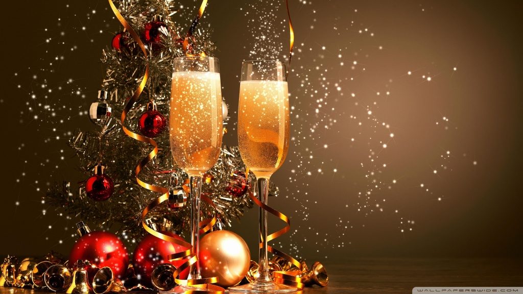 Novoročné pozadie s výzdobou z baniek a dvoma pohármi plnými šampanského.