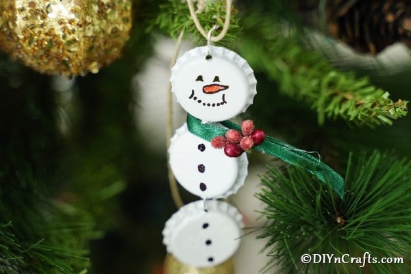Vianočný snehuliak z bielych zátok, zavesený na vetvičke vianočného stromčeka.