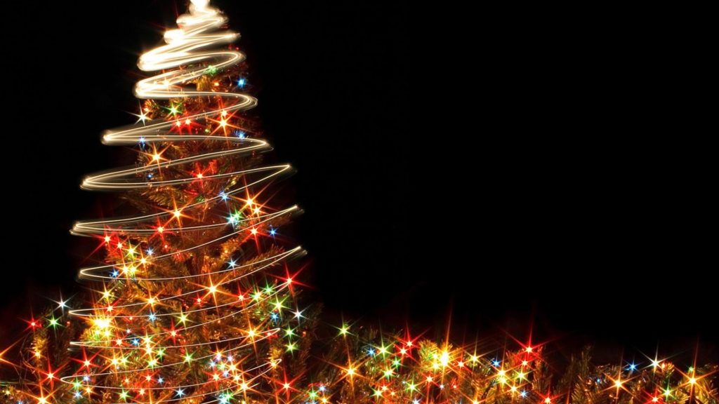 Farebne svietiaci vianočný strom na čiernom pozadí.