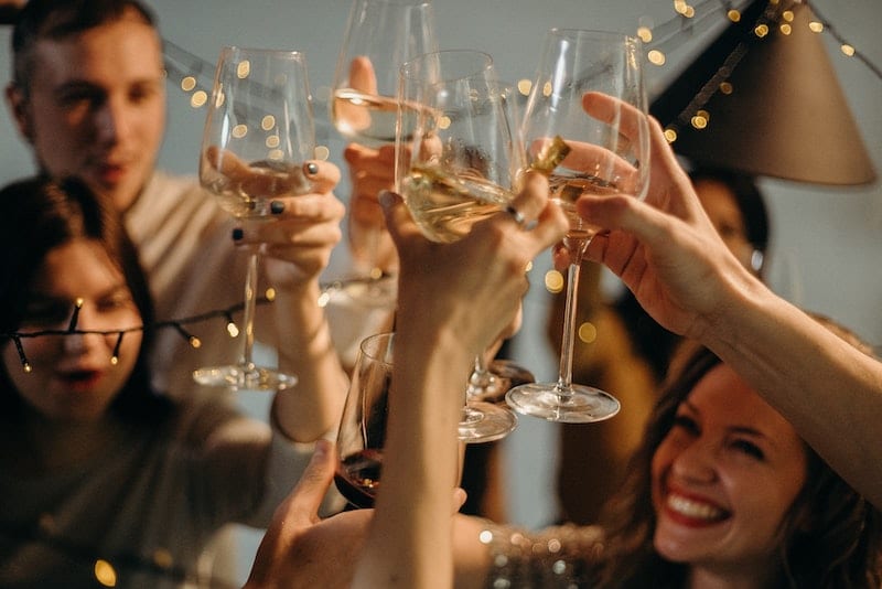 vianočný večierok, mnoho veselých ľudí si pripíja šampanským
