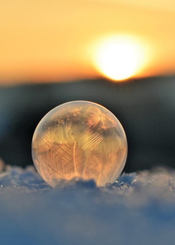 Snehová zamrznutá bublina na ľade, v pozadí západ slnka.
