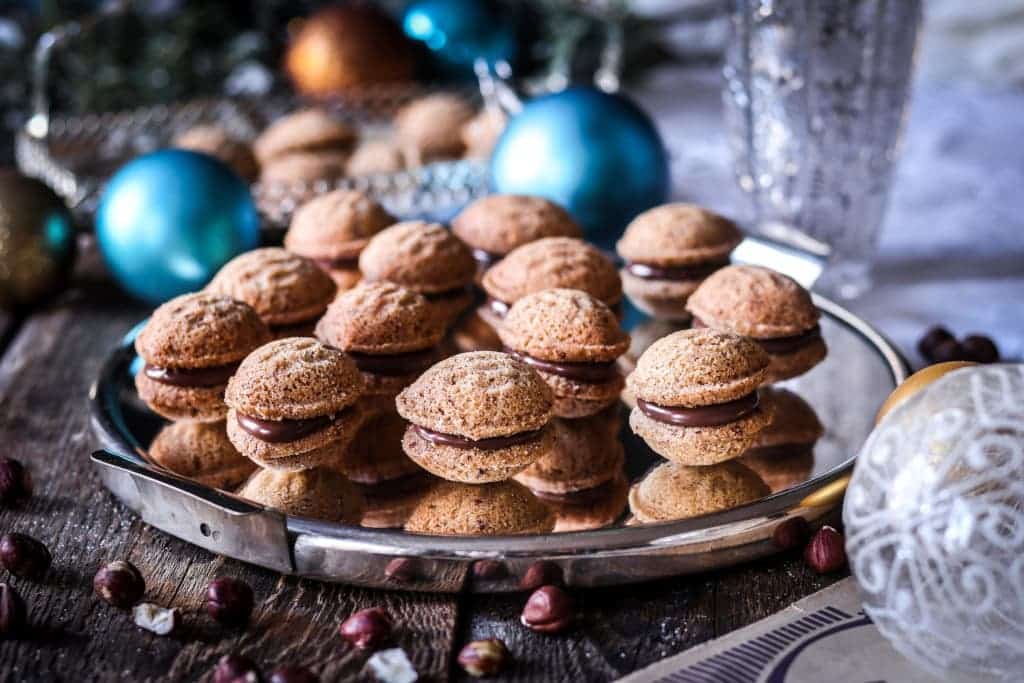 Vianočné orechy z ryžovej múky a lieskových orechov plnené liesko-orieškovým krémom na tácke.