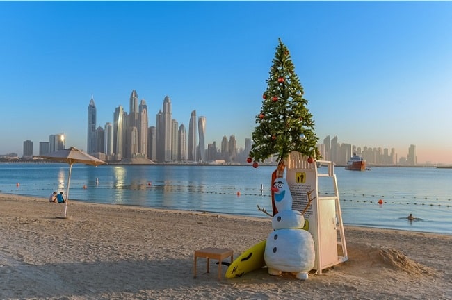Vianočný strom a snehuliak pri mori v Dubaji